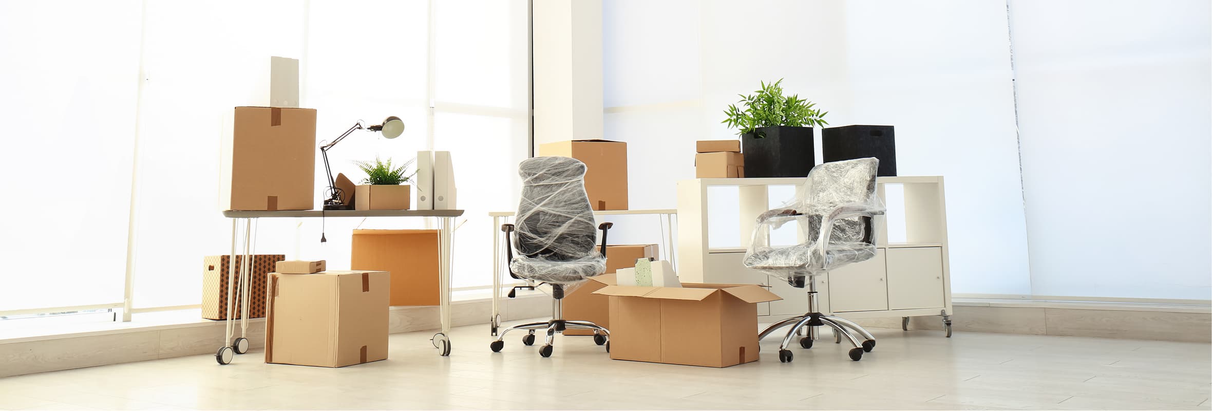 Packed office furniture and moving boxes prepared for an employee relocation